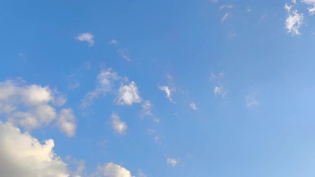 Curious orange clouds moving in the blue sky at sunset