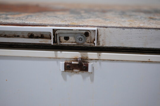 Close-up of a rusty metal door latch and hinge
