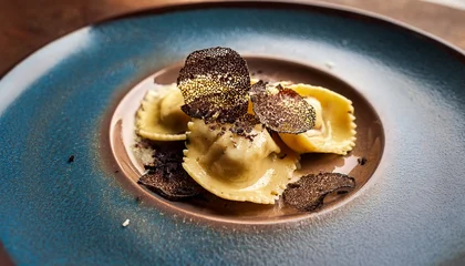 Acrylglasbilder Restaurant close up of truffle ravioli served on rustic plate delicious pasta dish with rich sauce and dark truffle shavings upscale dining experience for gourmet food lovers  © Marie K
