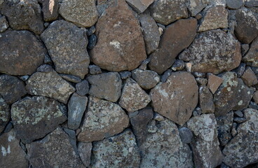 Traditional stone wall texture made of rough basalt volcanic rocks © Grigor