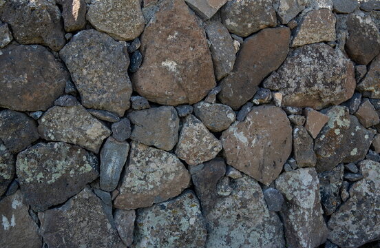 Traditional stone wall texture made of rough basalt volcanic rocks