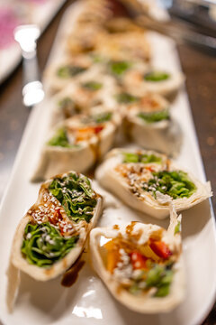 Fresh vegetarian wraps with sesame and greens served as healthy appetizer platter for parties and gatherings
