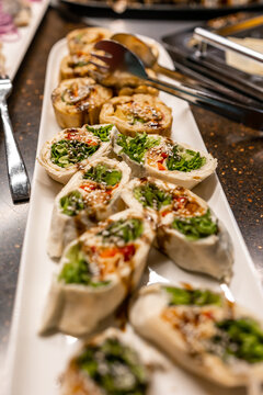 Fresh tortilla vegetable pinwheel wraps served on a platter at a buffet appetizer table
