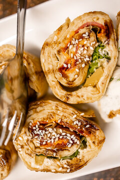 Savory sesame-topped rolled appetizers with vegetables and tangy glaze served as elegant finger food