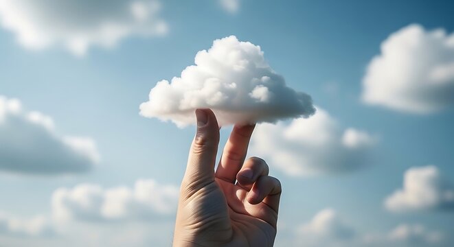 Person lifting fluffy white cloud against blue sky, dreamy outdoor lifestyle concept with natural light