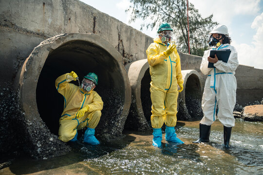 Environmental Inspection Team Conducting Coastal Wastewater Investigation While Wearing Hazardous Protective Equipment Near Industrial Drainage Area