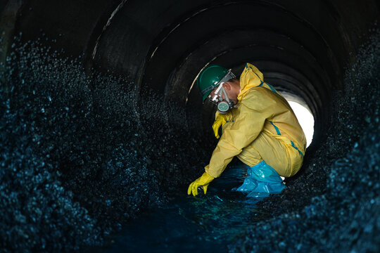 Environmental Workers Walking Inside Polluted Wastewater Tunnel During Industrial Contamination Inspection Wearing Hazardous Protective Equipment