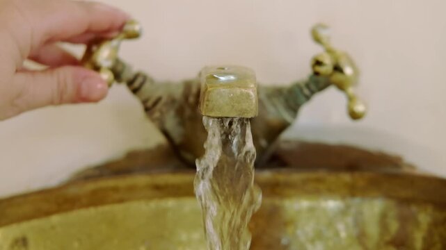 washing hands in Rustic brass sink, morning skincare routine in Moroccan-style interior, Self-care and mindfulness, basic hygiene and cultural touch in Morocco