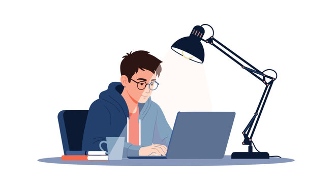 Young man wearing glasses and a blue hoodie working on his laptop late at night under the warm light of an adjustable desk lamp.
