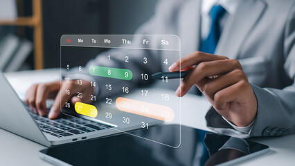 Fototapeta premium Businessman hand using stylus pen with virtual calendar for appointment and business planning. Time management, schedule organization and digital agenda concept with laptop in office.