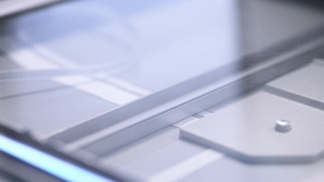 Close up details of flatbed scanner glass surface and internal scanning mechanism with soft lighting