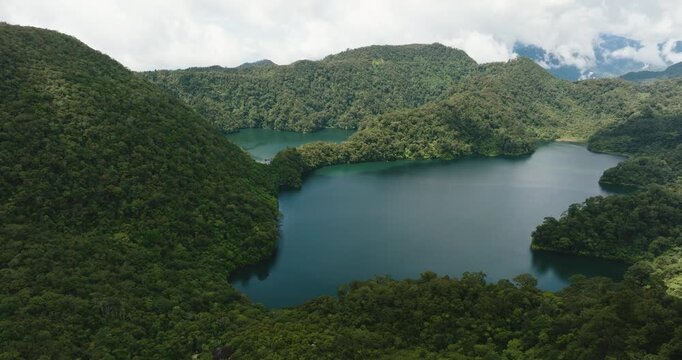 Aerial view of mountain lake surrounded by green forest. Balinsasayao Twin Lakes Natural Park. Negros, Philippines