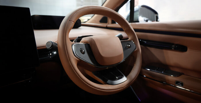 EV Car steering wheel. Modern car interior with luxury steering wheel dashboard and digital monitor controls. Steering wheel and automotive cabin. Car technology comfort and premium design in EV car.
