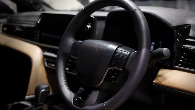 EV Car steering wheel. Modern car interior with luxury steering wheel dashboard and digital monitor controls. Steering wheel and automotive cabin. Car technology comfort and premium design in EV car.