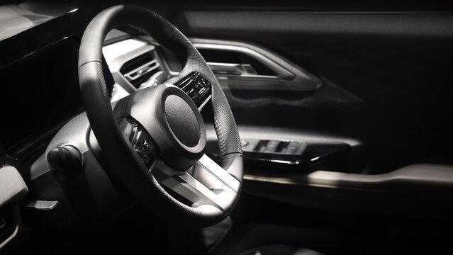 EV Car steering wheel. Modern car interior with luxury steering wheel dashboard and digital monitor controls. Steering wheel and automotive cabin. Car technology comfort and premium design in EV car.