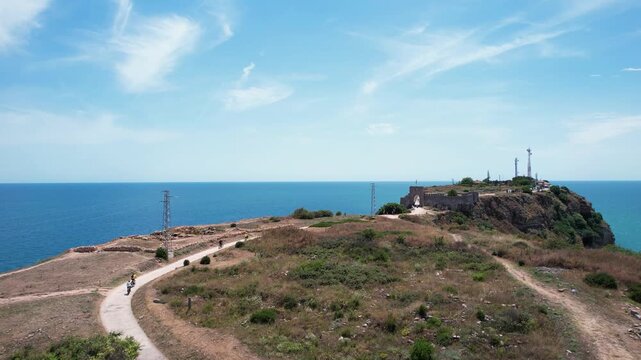 Aerial view of Kaliakra fortress ruins on a narrow peninsula with steep cliffs overlooking the Black Sea under a blue sky, Dobrich Province, Bulgaria.