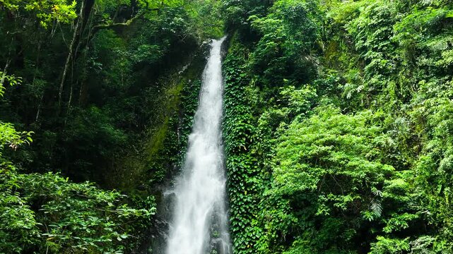 Aerial view of waterfall in the jungle. Slow motion. Pulang Tubig Falls. Negros, Philippines.