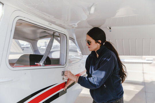 Pilot inspects small aircraft exterior