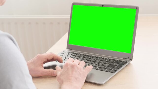 elderly man attempts to use laptop, green screen mockup, close-up of mature hands navigating, representing challenges and opportunities digital literacy for seniors, online communication