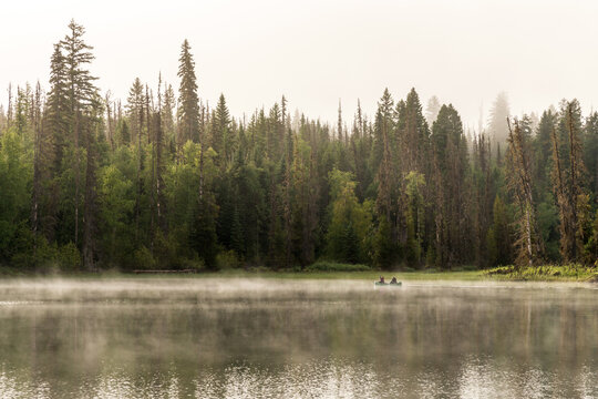 Canada, BC, Bowron Lake Provincial Park.  A canoe on Rum Lake early in morning mist