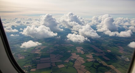 Obraz premium Aerial view of fluffy white clouds above green patchwork fields