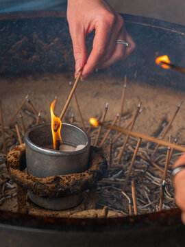 Single Hand Lighting Incense Above Flame Vertical Frame Japanese Shrine
