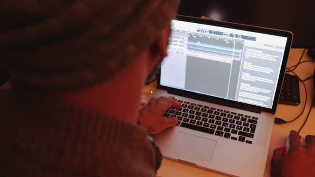 Person arbeitet im Homeoffice an Laptop mit Musikbearbeitung