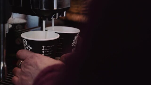 Nahaufnahme von frischem Cappuccino aus Kaffeemaschine in Pappbechern