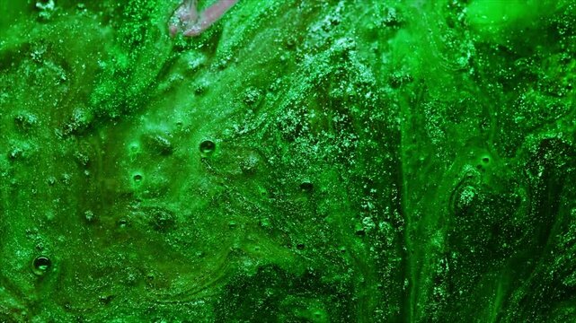 Close-up footage of green algae texture moving in water with bubbles