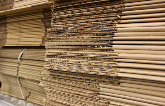 Warehouse shelf with stacked unopened cardboard boxes for packaging 
