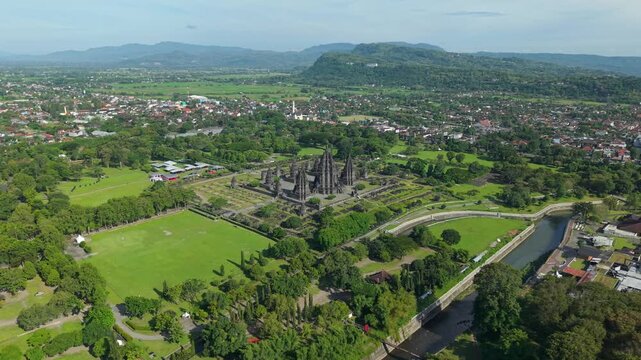 Aerial view of Prambanan Temple complex with its ancient stone spires surrounded by green lawns and trees in Kecamatan Prambanan, Daerah Istimewa Yogya, Indonesia.