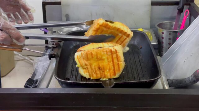 Street food vendor preparing indonesian grilled bread called roti bakar on a griddle.