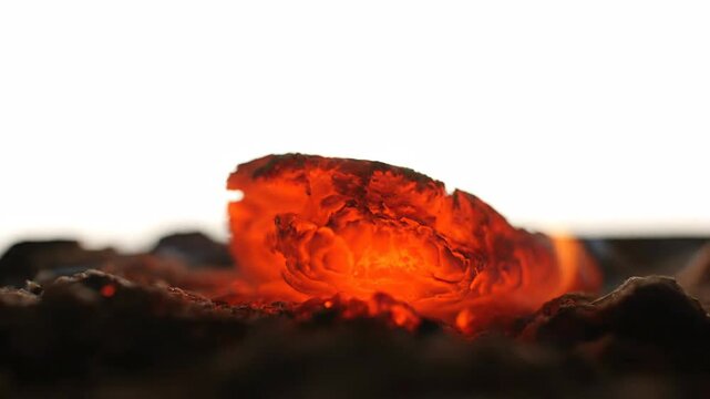 A close-up view of glowing embers creates a visually stunning scene. The intense warmth radiates