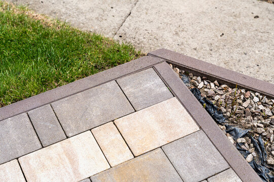 Close-up view of modern paving stones and grass edge in garden landscape, showcasing outdoor design and landscaping features for residential areas.