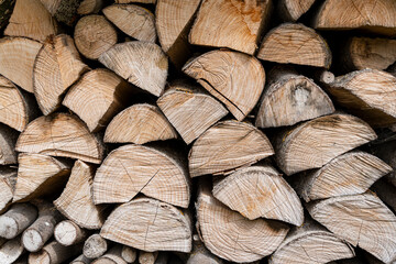 Fototapeta premium Stacked logs showing natural wood texture and patterns, ideal for concepts related to woodworking, sustainability, and rustic design environments.
