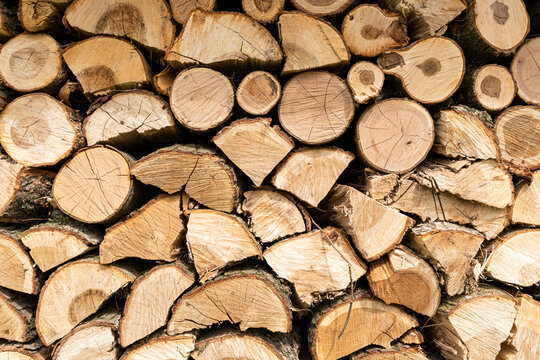 Stacked logs of wood in a natural rustic pattern, perfect for seasonal decorative themes and eco-friendly projects.