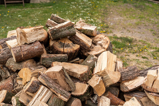 Stack of firewood logs arranged in an organic way, with different textures and colors, suitable for outdoor cooking or heating applications in a rustic setting
