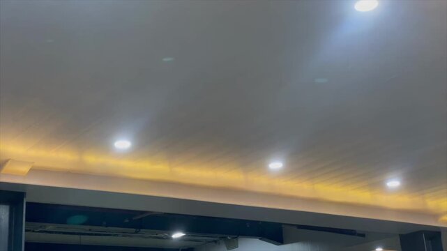 Interior ceiling lighting with white downlights and warm yellow hidden led.
