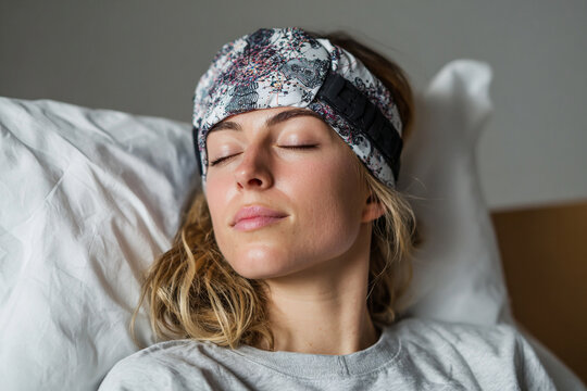 Young woman wearing a neurotechnology headband for brainwave monitoring and relaxation therapy. Neurowellness
