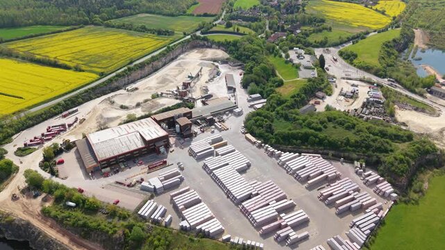 Aerial view of Marshalls industrial facility with stacks of building materials and surrounding green fields in Maltby, England, United Kingdom.