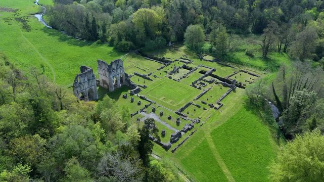 Aerial view of Roche Abbey ruins surrounded by lush green fields and dense forest in Maltby, England, United Kingdom.