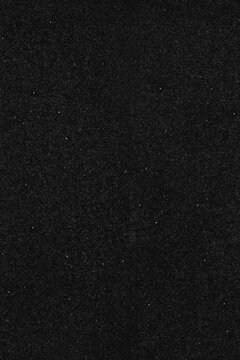 Dark film grain black paper seamless texture background. Old dust and scratch effect backdrop wallpaper.