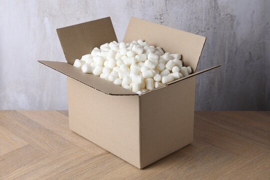 Cardboard box with styrofoam pieces on wooden table