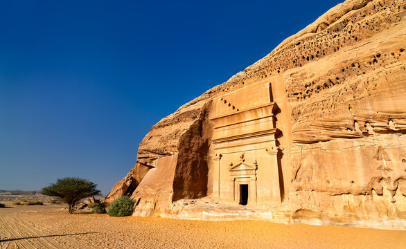 A prehistoric Nabatean tomb carved into a sandstone cliff in Hegra, a UNESCO World Heritage site in Al Ula, Saudi Arabia.