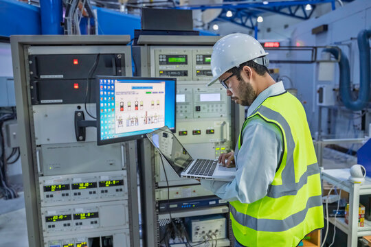 Professional engineer monitoring industrial automation system on digital screen in high-tech factory control room. Concept of smart manufacturing, technical data analysis, and modern engineering.