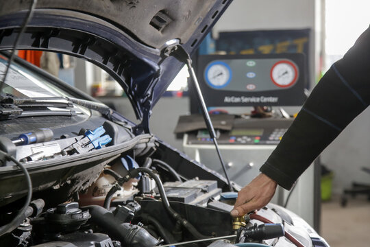 Car Air Conditioning Recharge Service with Freon Machine in Auto Repair Shop - Car AC Maintenance and Refrigerant Recharge Equipment in Garage