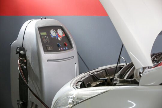Car Air Conditioning Recharge Service with Freon Machine in Auto Repair Shop - Car AC Maintenance and Refrigerant Recharge Equipment in Garage