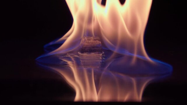 Ice and fire on black background. Ice cube on fire. . Slow motion 