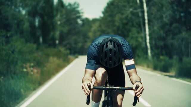 Cyclist Riding Road Bike On Asphalt Highway Through Forest. Athlete  High Speed Training Cycling For Competition 