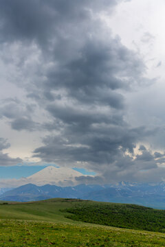 Landscape of snow-capped Elbrus and foothills in Caucasus mountains at summer